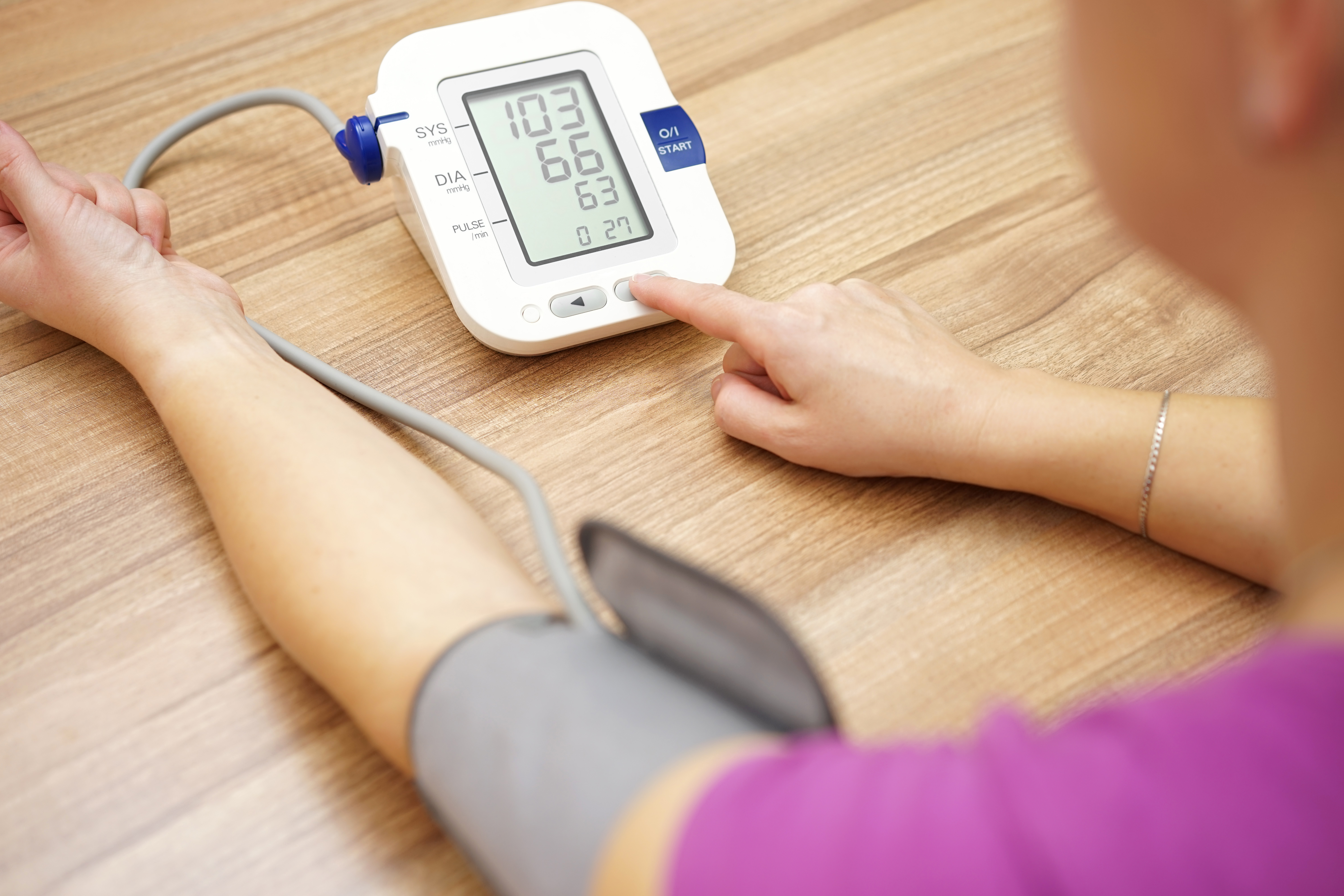 Image of female checking her own blood pressure.